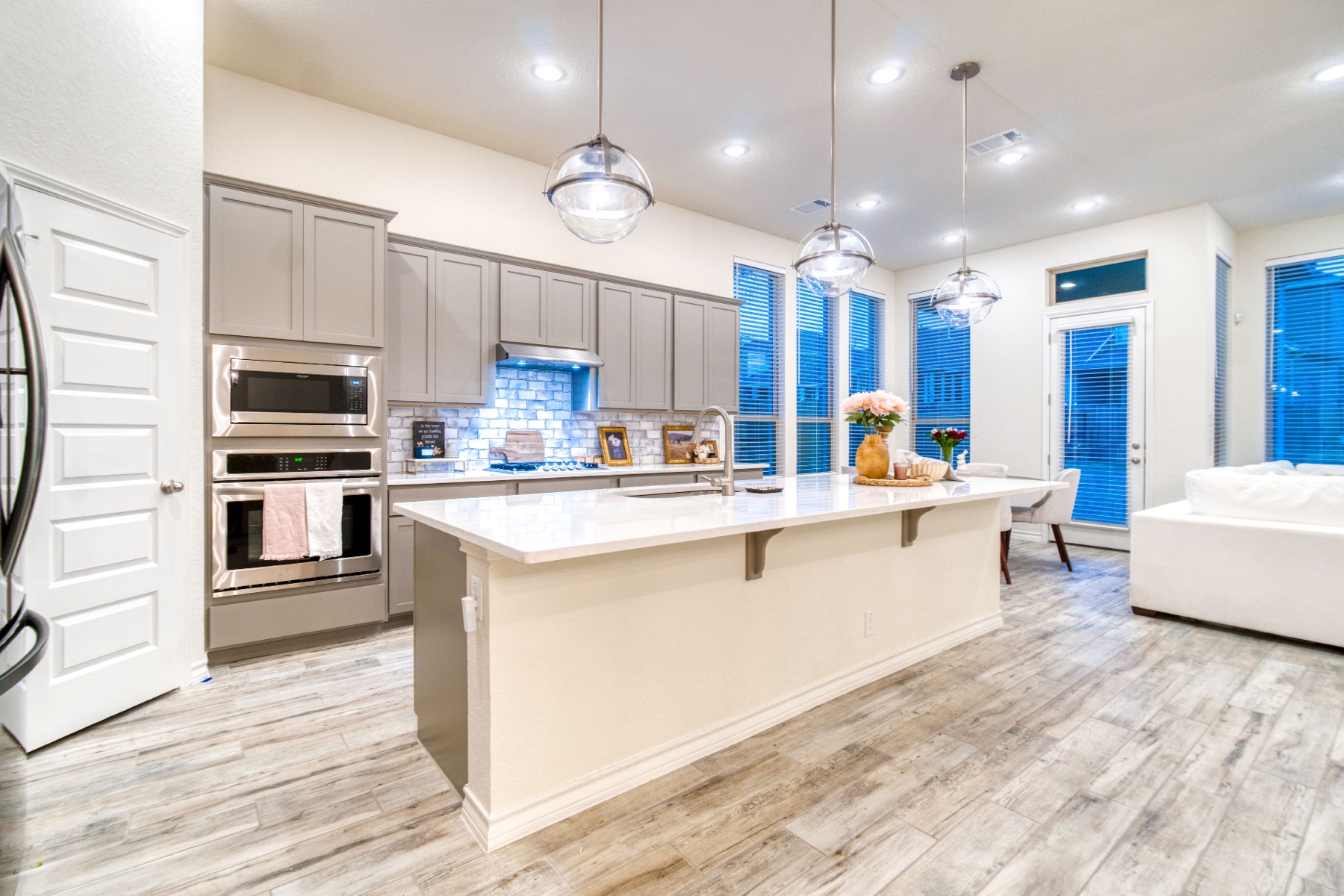 Remodeled kitchen with quartz waterfall island and globe pendants
